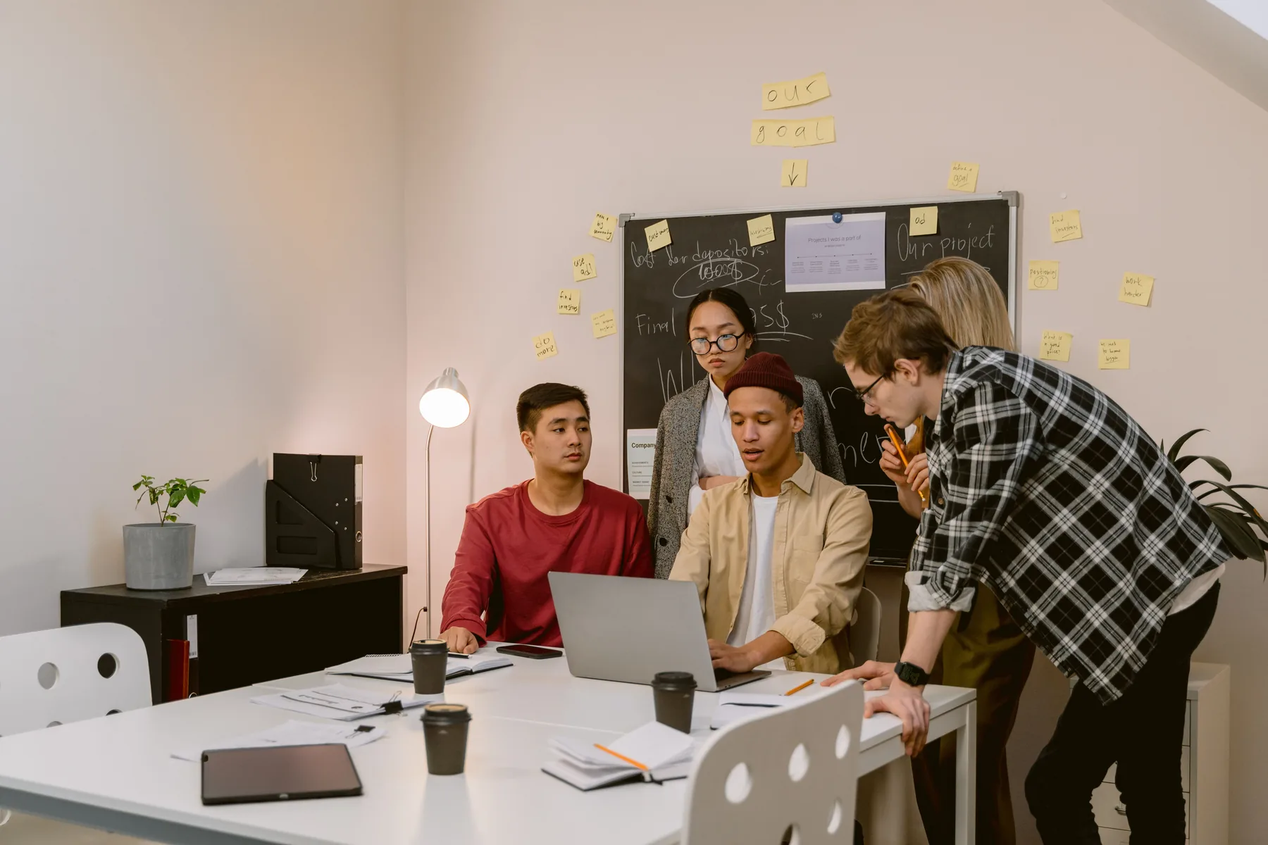 Team discusses a project around a laptop